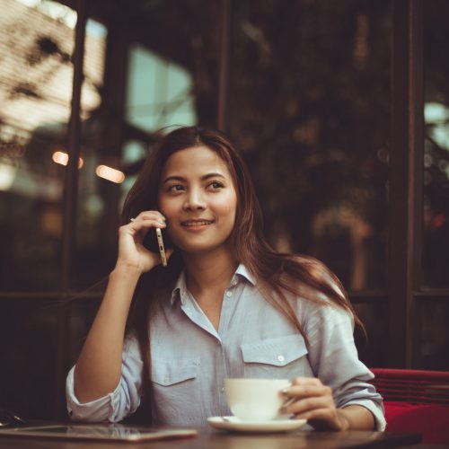 Asian woman drinking coffee in vintage color tone Asian woman drinking coffee in vintage color tone