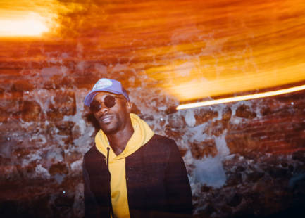 African man rapper among colorful light. Long exposure