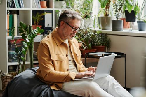 Serious mature businessman in casualwear and eyeglasses networking in office